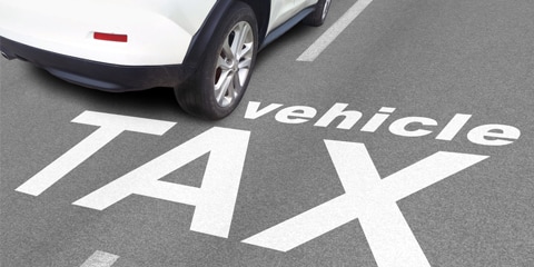 Image of an EV with the words vehicle tax written on a road